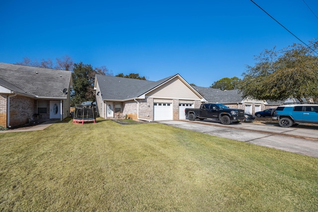 view of front facade with a garage, a trampoline, and a front lawn