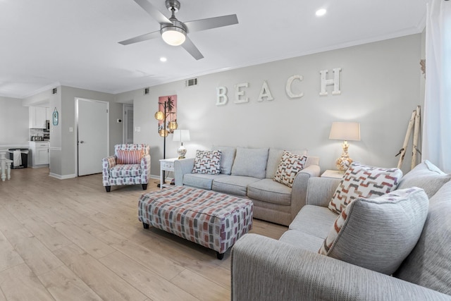 living room featuring light hardwood / wood-style floors, ceiling fan, and crown molding