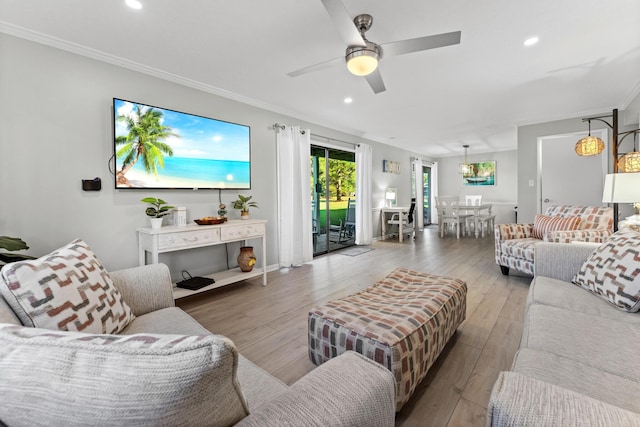 living room featuring ceiling fan, crown molding, and light wood-type flooring