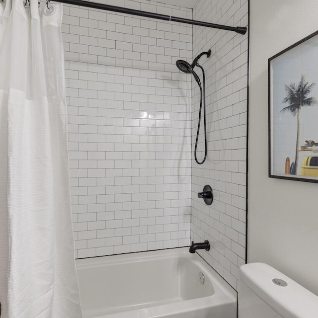 bathroom featuring shower / tub combo and toilet