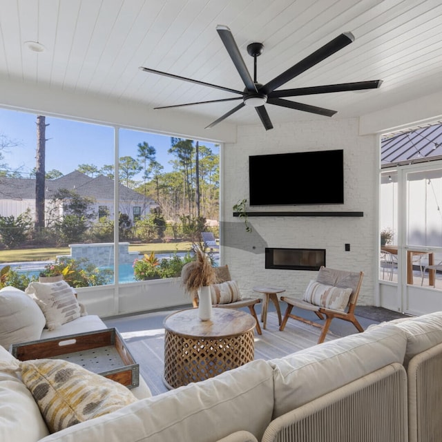 living room featuring ceiling fan, wood ceiling, and a brick fireplace