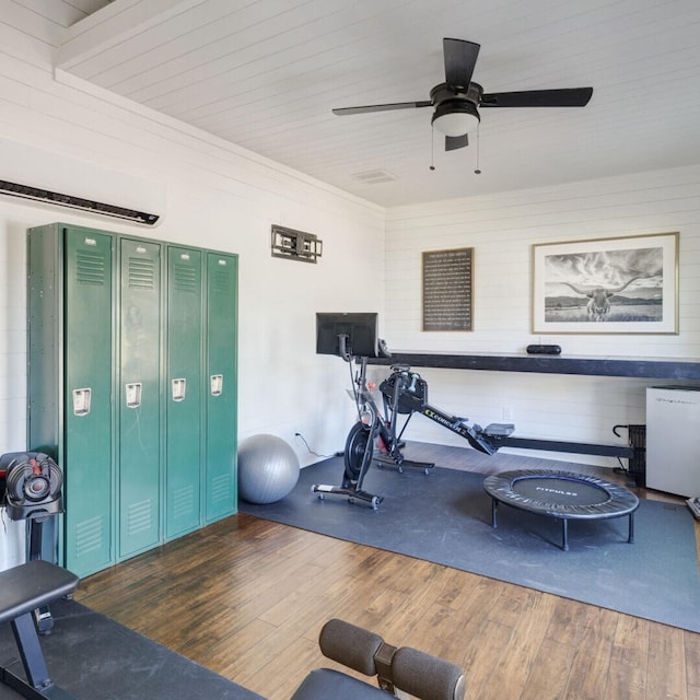 workout area featuring ceiling fan and dark hardwood / wood-style flooring