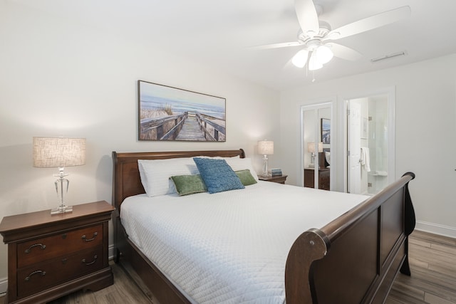 bedroom featuring hardwood / wood-style floors, ceiling fan, and ensuite bath