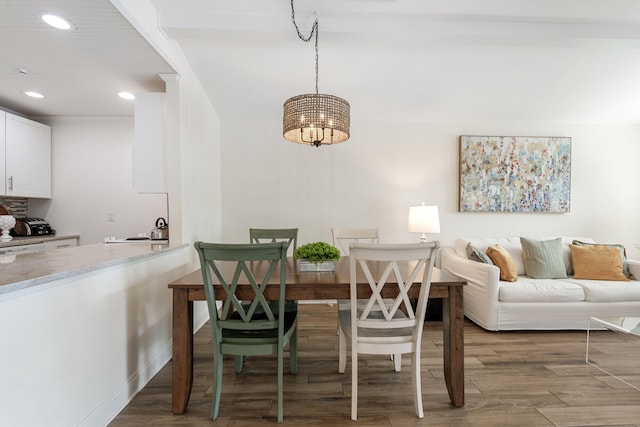 dining space with dark hardwood / wood-style floors and a notable chandelier