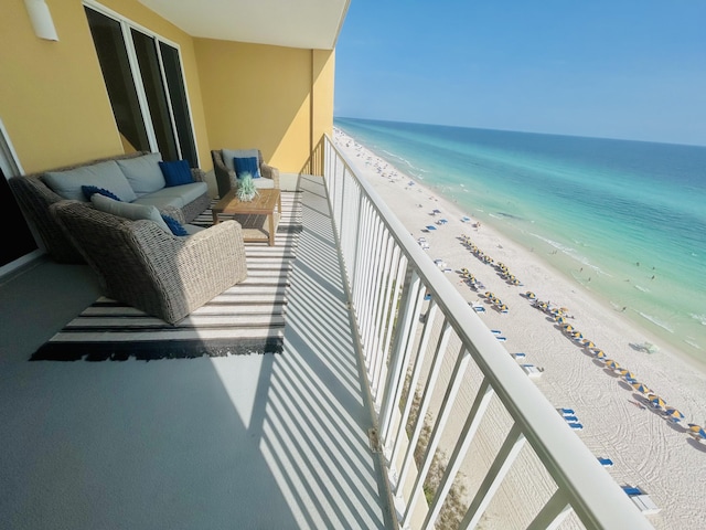 balcony with a view of the beach, an outdoor hangout area, and a water view