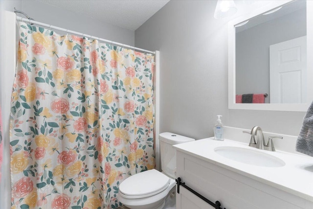 bathroom featuring a shower with curtain, vanity, toilet, and a textured ceiling