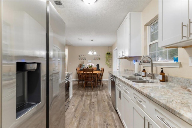 kitchen featuring white cabinets, light hardwood / wood-style floors, sink, and stainless steel appliances