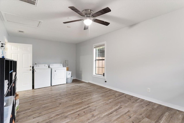 washroom with ceiling fan, washer and dryer, a textured ceiling, and light hardwood / wood-style floors