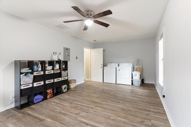 clothes washing area with hardwood / wood-style flooring, ceiling fan, and washing machine and dryer