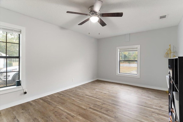 unfurnished room featuring ceiling fan, a textured ceiling, and light wood-type flooring