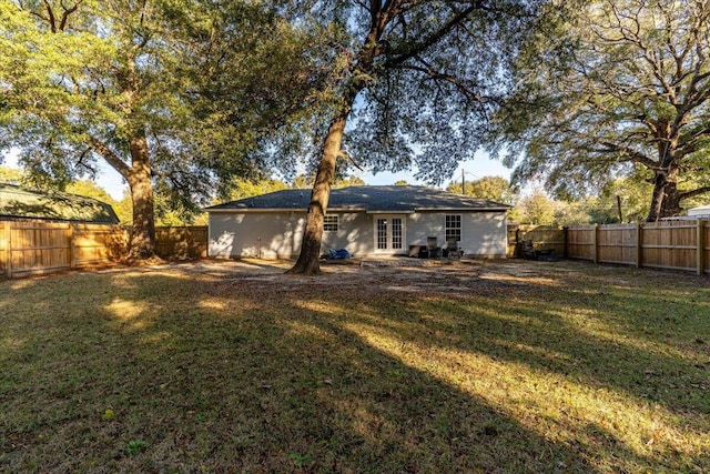 rear view of property with a lawn and french doors