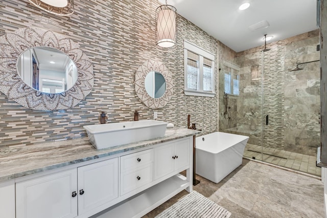 bathroom featuring vanity, tile walls, and independent shower and bath