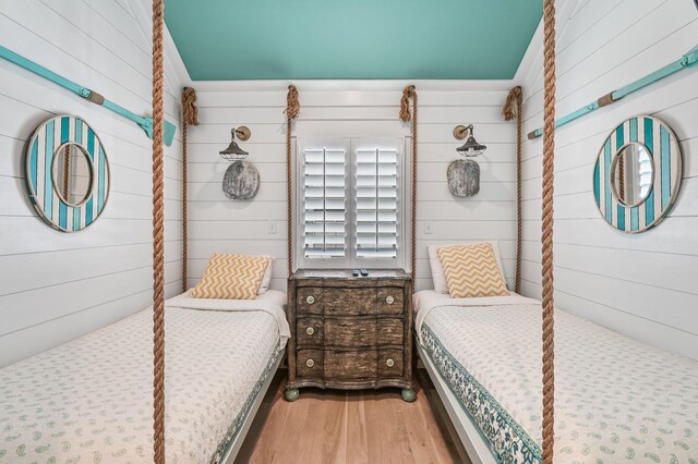 bedroom featuring wood walls and wood-type flooring