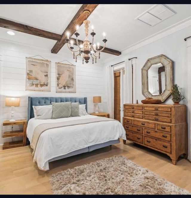 bedroom featuring wood walls, beam ceiling, light wood-type flooring, and a chandelier