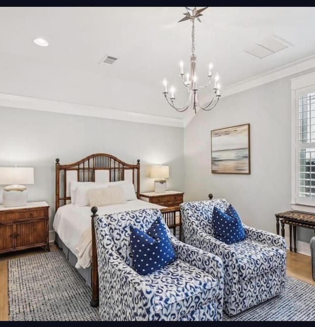 bedroom featuring wood-type flooring, an inviting chandelier, and crown molding