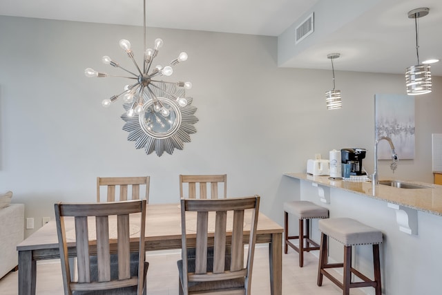 dining space with sink, a chandelier, and light hardwood / wood-style floors