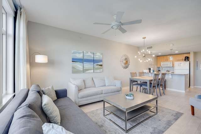 living room with light hardwood / wood-style flooring and ceiling fan with notable chandelier