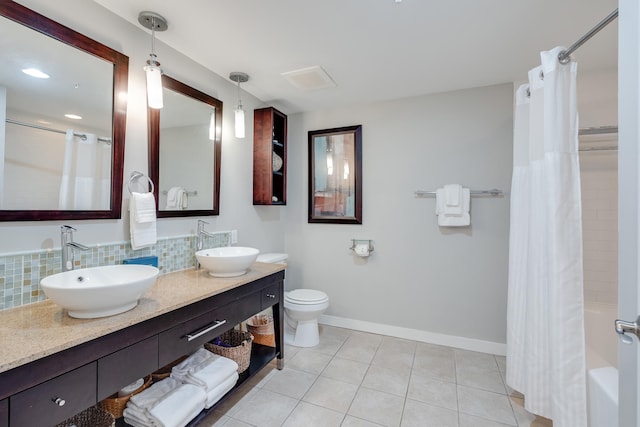 full bathroom with tasteful backsplash, tile patterned floors, toilet, shower / bath combo with shower curtain, and vanity