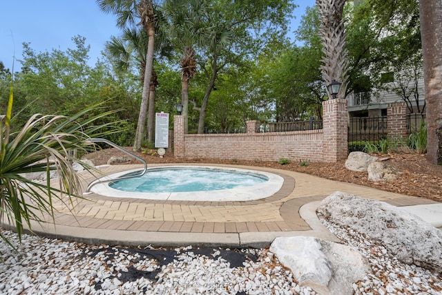 view of swimming pool featuring a hot tub