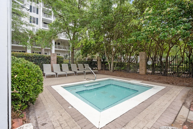 view of swimming pool with a hot tub