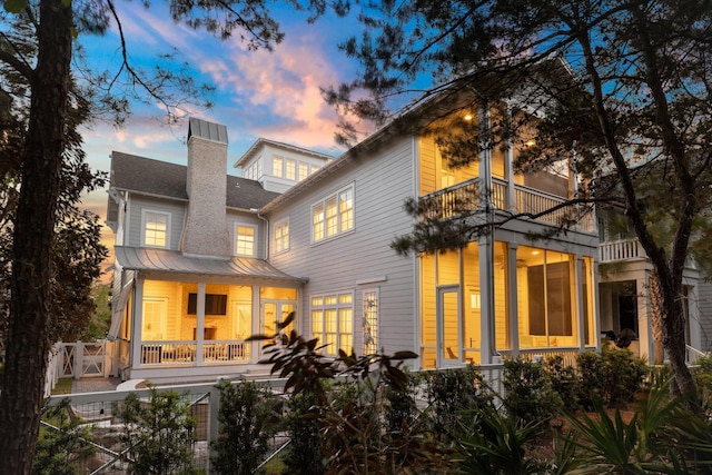 back house at dusk with a balcony