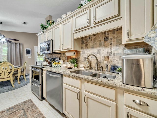 kitchen featuring cream cabinetry, ceiling fan, sink, and appliances with stainless steel finishes