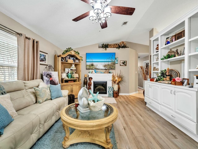 living room featuring ceiling fan, light hardwood / wood-style flooring, and lofted ceiling