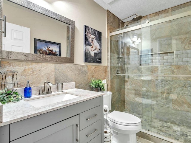 bathroom with walk in shower, a textured ceiling, toilet, vanity, and tile walls