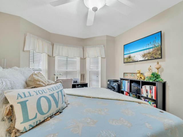 bedroom with ceiling fan and a textured ceiling