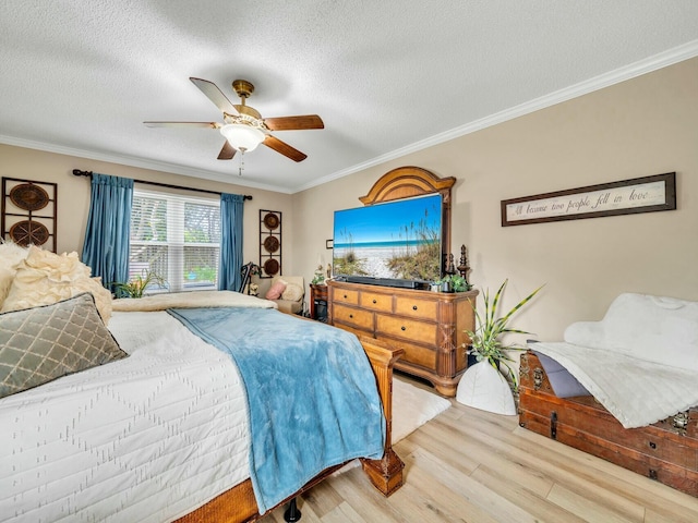 bedroom with light wood-type flooring, a textured ceiling, ceiling fan, and crown molding