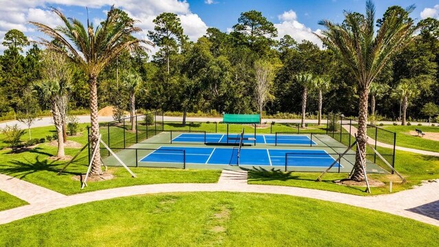 view of sport court with a lawn