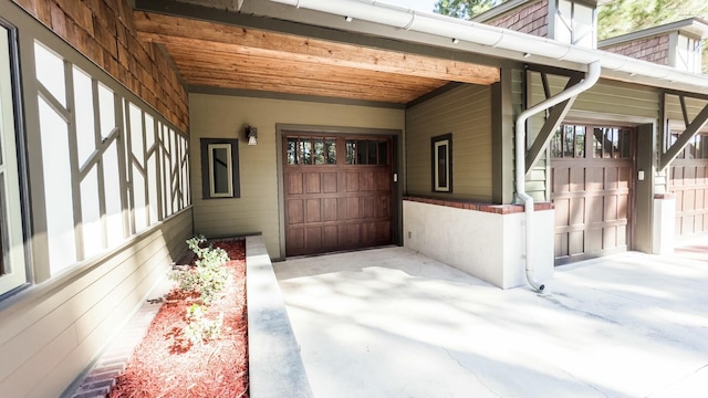 view of exterior entry featuring a garage and a carport