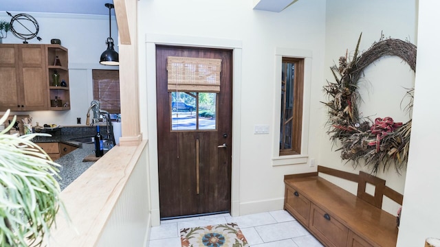 entrance foyer with light tile patterned flooring and sink