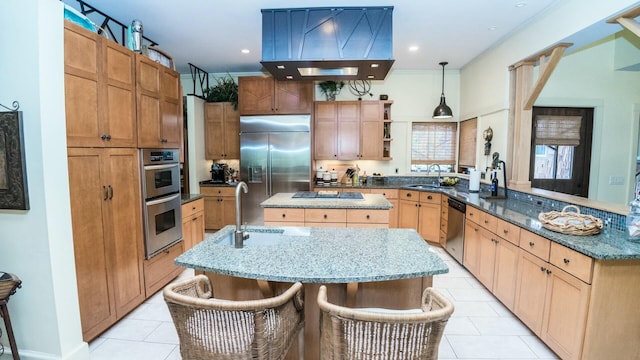 kitchen with a center island with sink, sink, hanging light fixtures, a breakfast bar area, and stainless steel appliances