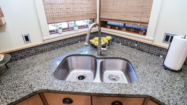 room details featuring sink, backsplash, and stone counters