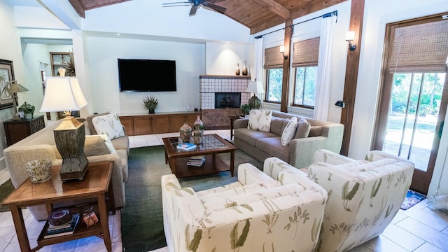 tiled living room featuring vaulted ceiling with beams, ceiling fan, wooden ceiling, and a fireplace