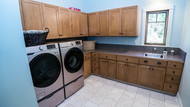 clothes washing area featuring cabinets, separate washer and dryer, and sink