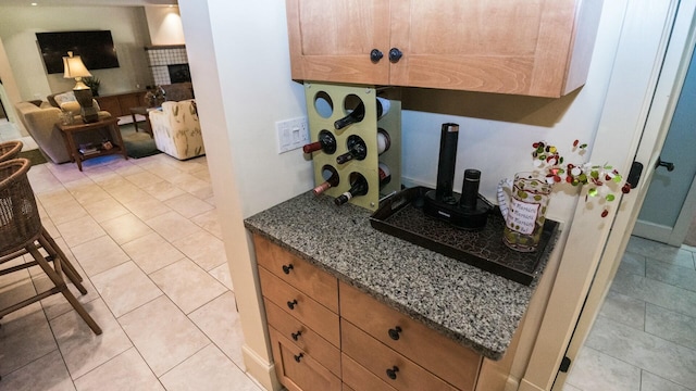 kitchen with light tile patterned floors and dark stone countertops