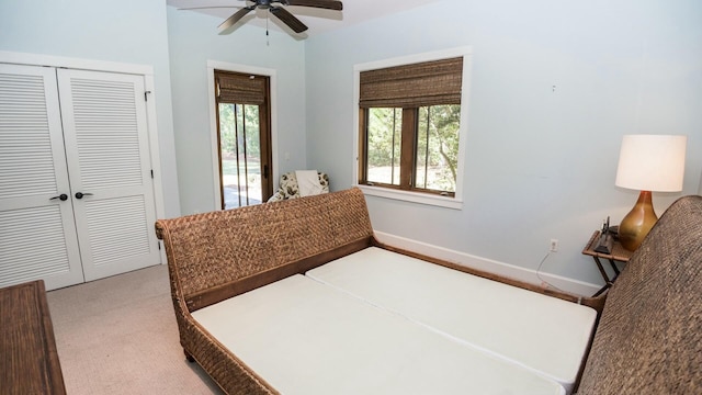 carpeted bedroom with ceiling fan and a closet