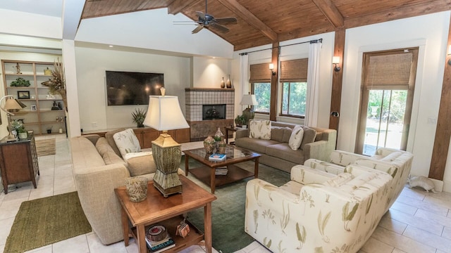 living room featuring lofted ceiling with beams, ceiling fan, light tile patterned floors, wood ceiling, and a tiled fireplace