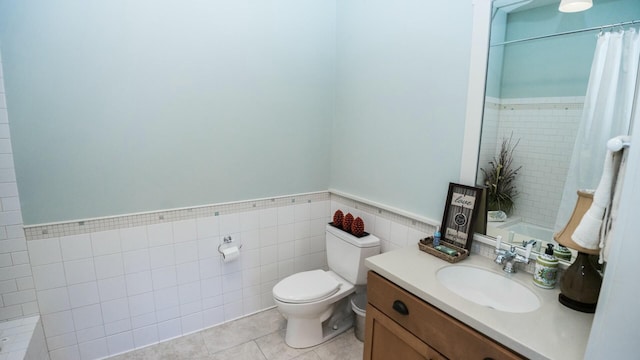 bathroom with tile patterned floors, vanity, toilet, and tile walls