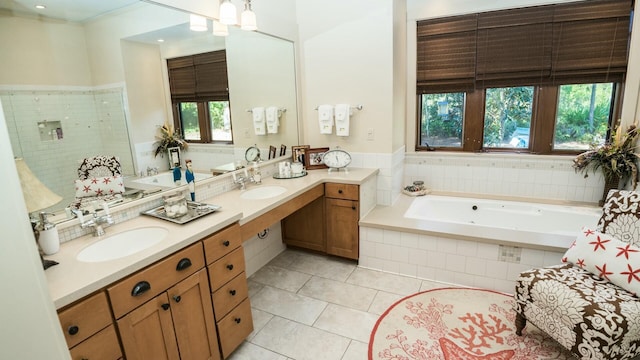 bathroom with tile patterned floors, vanity, and a relaxing tiled tub