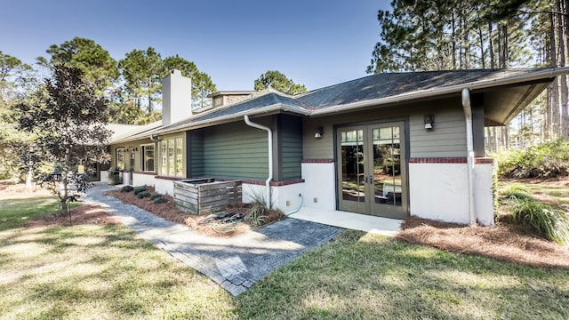 view of front of property with french doors and a front lawn