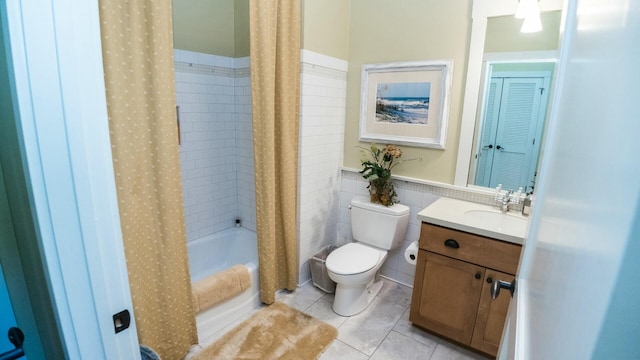 full bathroom with shower / tub combo, tile patterned floors, toilet, vanity, and tile walls