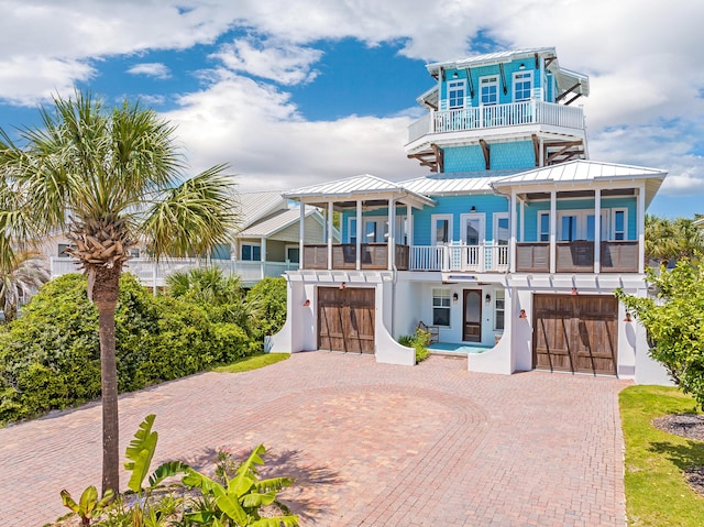 coastal inspired home featuring a balcony and a garage