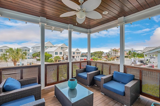 sunroom / solarium with ceiling fan, plenty of natural light, and wood ceiling