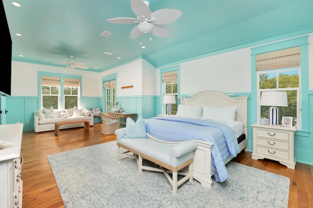 bedroom featuring multiple windows, hardwood / wood-style flooring, and ceiling fan