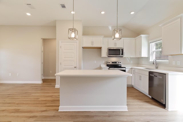 kitchen with appliances with stainless steel finishes, white cabinetry, hanging light fixtures, and a center island