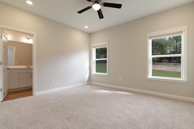 interior space featuring ceiling fan, light colored carpet, and sink