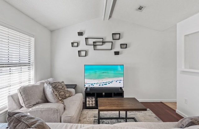 living room with wood-type flooring and lofted ceiling with beams